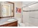 Bathroom showcasing a sleek vanity with a dark wood cabinet, stylish mirror, and modern tiled shower with glass door at 16419 Chapman Crossing Dr, Lithia, FL 33547