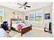 Bedroom features natural light, a ceiling fan, a wooden bed frame, and colorful decor at 16419 Chapman Crossing Dr, Lithia, FL 33547