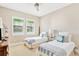 Sunlit bedroom with twin beds, plantation shutters, and tasteful decor for a serene atmosphere at 16419 Chapman Crossing Dr, Lithia, FL 33547