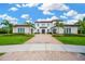 Stately two-story home with lush landscaping, a paver driveway, and a tile roof at 16419 Chapman Crossing Dr, Lithia, FL 33547