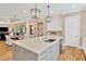 Kitchen island with stainless dishwasher and sink; dining room in background at 16419 Chapman Crossing Dr, Lithia, FL 33547