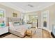 A spacious main bedroom with a sitting area, ceiling fan, and plenty of natural light at 16419 Chapman Crossing Dr, Lithia, FL 33547