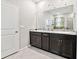 Bathroom vanity with granite countertops, dual sinks, dark wood cabinetry, and a large mirror at 16625 Goose Ribbon Pl, Wimauma, FL 33598