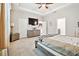 Bright bedroom with tray ceilings, neutral palette, ceiling fan, and dresser at 16625 Goose Ribbon Pl, Wimauma, FL 33598