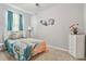 Cozy bedroom with a colorful bedspread, ceiling fan, and a decorative accent wall at 16625 Goose Ribbon Pl, Wimauma, FL 33598