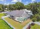 The aerial view showcases the home's private pool, patio, fenced yard, and the surrounding lush greenery at 1727 Woodpond Way, Lutz, FL 33559
