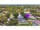 An aerial perspective highlights the home, screened-in pool, and a lush, tree-filled neighborhood at 1727 Woodpond Way, Lutz, FL 33559