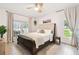 Bright bedroom featuring a bed, ceiling fan, rug, and windows that bring in natural light at 1727 Woodpond Way, Lutz, FL 33559