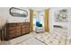 Comfortable bedroom with a dresser, soft chair, decorative mirror, and bright natural light from two windows at 1727 Woodpond Way, Lutz, FL 33559