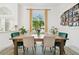 Bright dining area with a large window, wooden table, and seating for six at 1727 Woodpond Way, Lutz, FL 33559