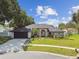 Charming single-story home with brick accents, a driveway, and landscaping at 1727 Woodpond Way, Lutz, FL 33559
