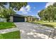Charming single-story home with a well-manicured lawn and an expansive driveway at 1727 Woodpond Way, Lutz, FL 33559