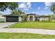 Charming single-story home with a well-manicured lawn and beautiful landscaping at 1727 Woodpond Way, Lutz, FL 33559