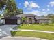 Charming single-story home with a well-manicured lawn and beautiful landscaping at 1727 Woodpond Way, Lutz, FL 33559