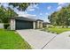 Charming single-story home featuring a well-manicured lawn and an expansive driveway at 1727 Woodpond Way, Lutz, FL 33559