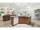 Kitchen island open to the living room with wood cabinets, granite countertops, and dishwasher at 1727 Woodpond Way, Lutz, FL 33559