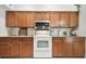 Updated kitchen featuring wood cabinets, white appliances, and granite countertops at 1727 Woodpond Way, Lutz, FL 33559
