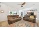 Bright living room with vaulted ceiling, ceiling fan, tile floors, and sliding glass doors to the outdoors at 1727 Woodpond Way, Lutz, FL 33559