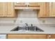 Close up of the kitchen sink with light wood cabinets and white backsplash at 2430 Florentine Way # 46, Clearwater, FL 33763