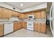 Bright kitchen featuring a white range, microwave and ample light wood cabinetry at 2430 Florentine Way # 46, Clearwater, FL 33763