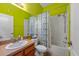 Cozy bathroom with wooden vanity, shower/tub and bright green walls at 2539 Centennial Falcon Dr, Valrico, FL 33596