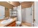 Small bathroom with wood vanity, decorative mirror and combination shower/tub at 2539 Centennial Falcon Dr, Valrico, FL 33596