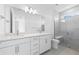 Bright bathroom featuring double sinks, white cabinets, and a walk-in shower with glass door at 27148 Capri Shores Cir, Englewood, FL 34223