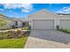 Charming home exterior with a paved driveway, two-car garage, and beautiful landscaping at 27148 Capri Shores Cir, Englewood, FL 34223
