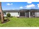 Home's exterior showcases a screened-in patio and lush, manicured lawn at 27152 Capri Shores Cir, Englewood, FL 34223