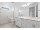 Bathroom featuring double sinks with quartz countertops, a large mirror, and glass-enclosed shower at 27152 Capri Shores Cir, Englewood, FL 34223
