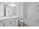 Bright bathroom featuring a white vanity with stone countertop, toilet and tiled shower at 27156 Capri Shores Cir, Englewood, FL 34223