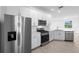 Modern kitchen with stainless steel appliances, white cabinets, and tiled backsplash at 27156 Capri Shores Cir, Englewood, FL 34223