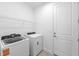 Convenient laundry room featuring a Whirlpool washer and dryer and wire shelving at 27156 Capri Shores Cir, Englewood, FL 34223