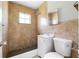 Tiled bathroom featuring a walk-in shower, tiled walls, a window, and a vanity sink at 2916 E North St, Tampa, FL 33610