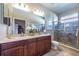 Bathroom with double sinks, granite countertops, and tiled shower at 305 Bluewater Falls Ct, Apollo Beach, FL 33572