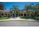 Exterior of the Del Webb clubhouse with palm trees and well manicured landscaping at 305 Bluewater Falls Ct, Apollo Beach, FL 33572