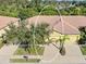 Front exterior featuring a well-maintained lawn, driveway, and palm trees at 305 Bluewater Falls Ct, Apollo Beach, FL 33572