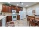 Functional kitchen design features wooden cabinetry, white appliances, and adjacent dining area at 305 Bluewater Falls Ct, Apollo Beach, FL 33572