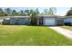 Charming home with a red door, garage, and a well-manicured lawn at 3066 19Th Sw Pl, Largo, FL 33774