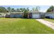 Charming home with a red door, garage, and a well-manicured lawn at 3066 19Th Sw Pl, Largo, FL 33774