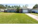 Charming home with a red door, garage, and a well-manicured lawn at 3066 19Th Sw Pl, Largo, FL 33774