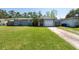 Charming home with a red door, garage, and a well-manicured lawn at 3066 19Th Sw Pl, Largo, FL 33774