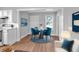 Dining area featuring a round table with blue chairs, wooden floors, and a white chair at 3409 N 10Th St, Tampa, FL 33605