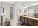 Elegant bathroom featuring double sinks with granite countertops and neutral tile flooring at 3503 Gaviota Dr, Sun City Center, FL 33573