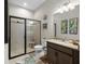 A modern bathroom with granite countertop vanity, sleek glass shower, and stylish fixtures at 3503 Gaviota Dr, Sun City Center, FL 33573