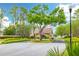 Charming community entrance surrounded by mature trees and lush landscaping under a bright blue sky at 3503 Gaviota Dr, Sun City Center, FL 33573