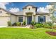 Beautifully landscaped front yard showcasing the home's architecture, including a welcoming entryway and well-maintained lawn at 3503 Gaviota Dr, Sun City Center, FL 33573