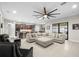 Open-concept living space with a large sectional, modern lighting, and seamless access to the kitchen and outdoor patio at 3503 Gaviota Dr, Sun City Center, FL 33573