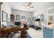 A home office with a large wooden desk, comfortable seating, and a ceiling fan at 3503 Gaviota Dr, Sun City Center, FL 33573
