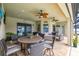 Covered outdoor patio area with a dining table, ceiling fans and outdoor kitchen at 3503 Gaviota Dr, Sun City Center, FL 33573